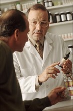 Pharmacist talking to customer. Photographe : Rob Lewine