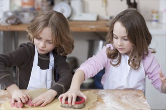 Young girls baking cookies. Photographe : Dan Bannister