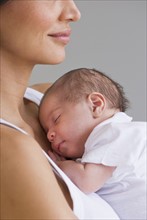 Mother holding sleeping baby.