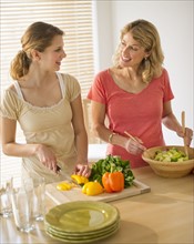 Two women preparing salad.