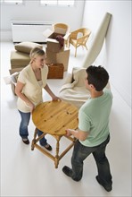 Couple moving furniture in their new home.