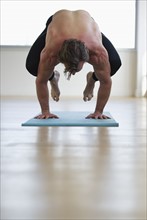 Man doing workout on yoga mat. Photo : Daniel Grill
