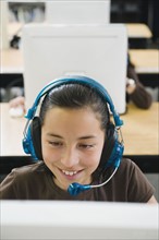Elementary student wearing headphones in classroom.