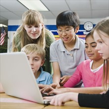 Elementary students looking at laptop.