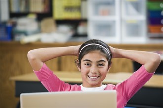 Elementary student relaxing at her desk.