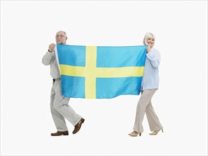 Two people carrying the flag the Swedish flag. Photo : momentimages