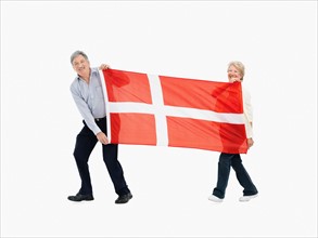 Two people carry the Danish flag. Photo : momentimages