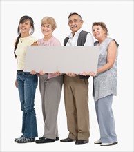 Four people holding a blank poster. Photo : momentimages
