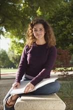 Teenage student sitting on park bench. Photo : Stewart Cohen