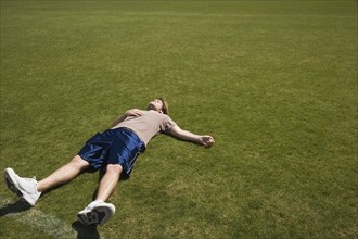 Defeated athlete lying on grass. Photo : Stewart Cohen