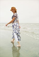Woman walking on the beach. Photo : Shawn O'Connor