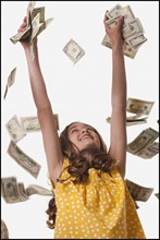 Young girl throwing money in the air. Photo : Mike Kemp