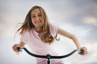 Pretty teenage girl riding a bike. Photo : Mike Kemp