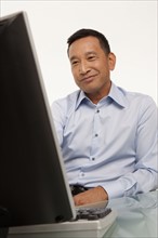 Smiling man working on computer. Photo : K.Hatt