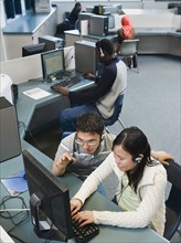 Adult students working on computers at a learning center.