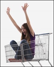 Excited woman sitting in a shopping cart. Photo : Mike Kemp