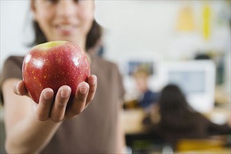 Elementary student holding an apple in her hand.
