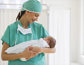 Nurse holding swaddled baby.
