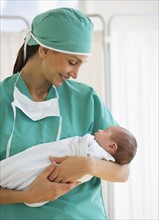 Nurse holding swaddled baby.