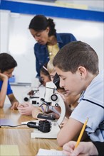 Elementary students using microscopes.