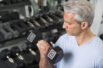 Man lifting free weights at the gym.