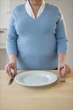 Overweight woman setting the table.