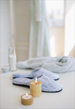 Candles slippers and robe at spa.