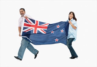 Two people carry the New Zealand flag. Photo : momentimages