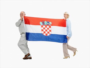 Two people carrying the Croatian flag. Photo : momentimages