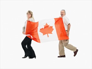 Two people carrying the Canadian flag. Photo : momentimages