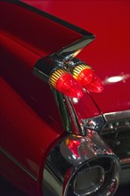 Tail fin on a 1959 red automobile.