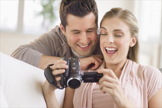 Couple looking at picture on video camera.