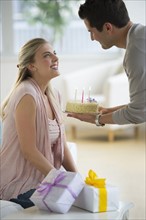 Man giving birthday cake to woman.