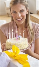 Woman holding birthday cake.
