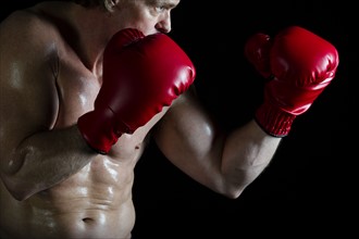 Boxer wearing red boxing gloves. Photo : Daniel Grill