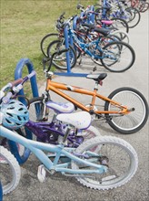 Row of children's bicycles locked up in school yard.
