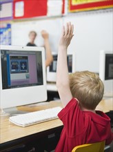 Student raising hand in classroom.