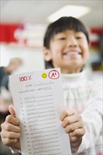 Elementary student holding an A grade paper.