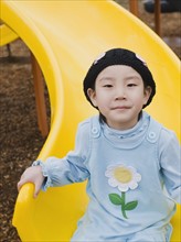 Elementary school student playing on slide at recess.
