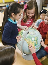 Kindergarten students looking at globe.
