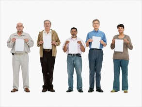 Group of people standing in a row holding papers. Photo : momentimages