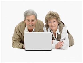 Retired couple looking at laptop together. Photo : momentimages