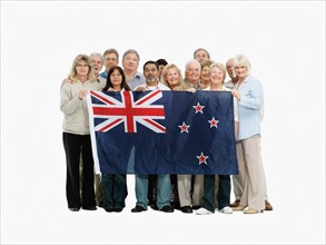 Group of people holding the New Zealand flag. Photo : momentimages