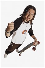 Teenage boy holding skateboard. Photo : Stewart Cohen