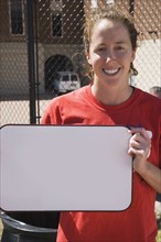 Teenage girl holding blank whiteboard. Photo : Stewart Cohen