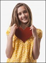 Teenage girl holding heart. Photo : Mike Kemp