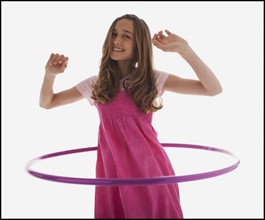 Teenage girl playing with a hula hoop. Photo : Mike Kemp