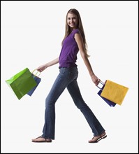 Teenage girl walking with several shopping bags. Photo : Mike Kemp