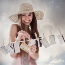 Woman hanging credit cards on clothesline. Photo : Mike Kemp