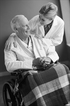 Doctor talking to senior man in wheelchair. Photo : Rob Lewine